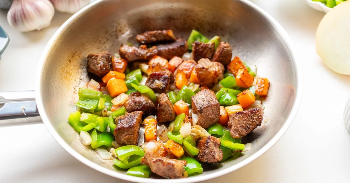 Délicieux sauté de bœuf, de poivrons et de carottes dans une poêle pour un repas dynamique.